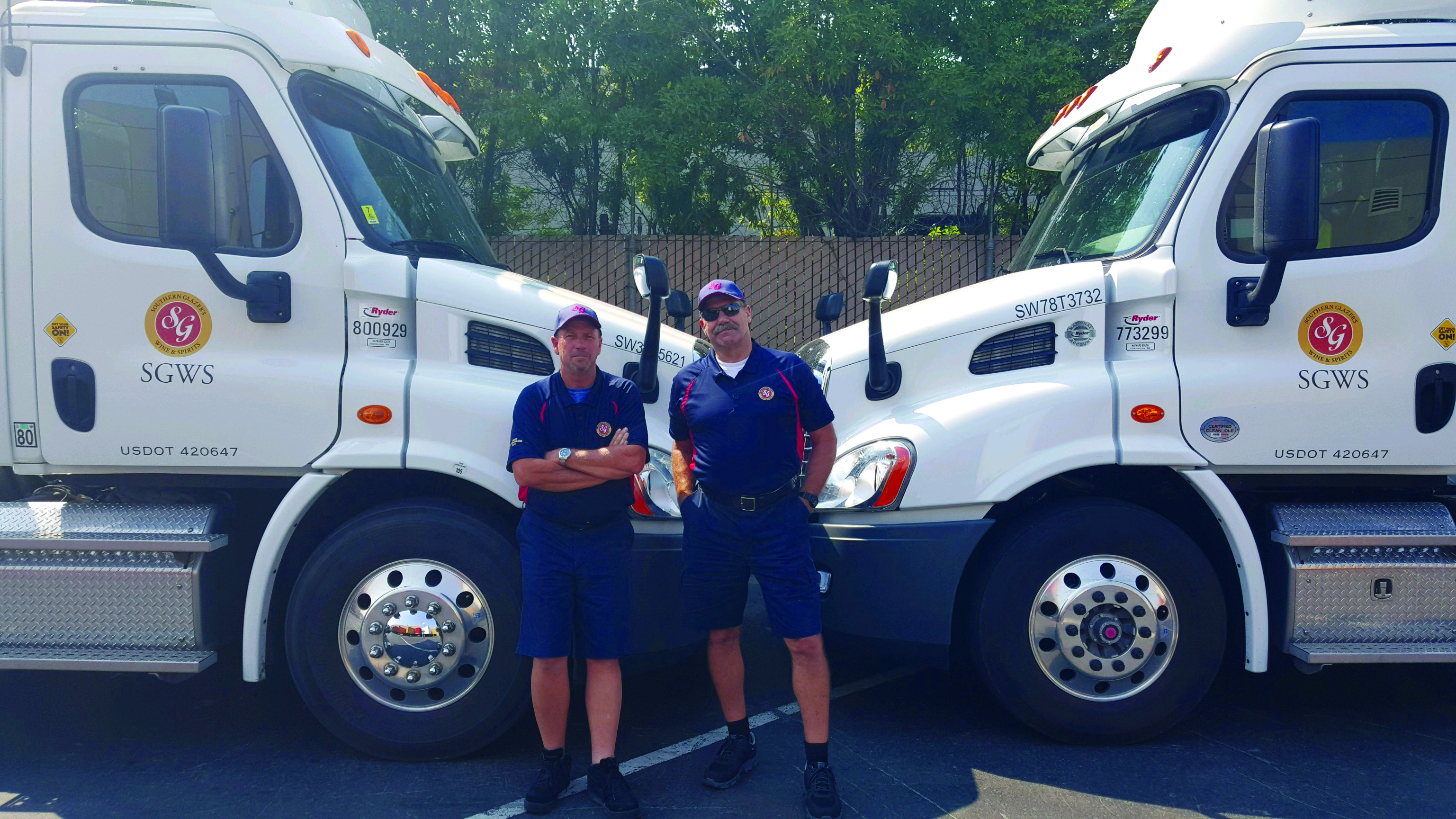 Two drivers standing in front of trucks